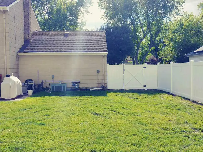 White vinyl fence in residential neighborhood by Fencing By Excellence near Howell, Monmouth County NJ